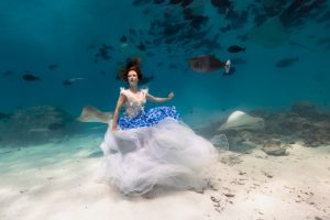 Deutsches Unterwassermodel Katrin Gray umgeben von Rochen